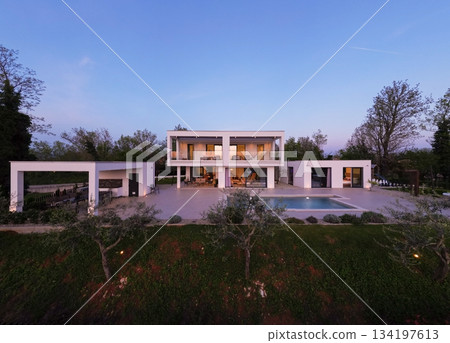 Modern luxury villa illuminated at night with pool, terraces, and contemporary architecture. Warm lighting and elegant outdoor living create a stylish and sophisticated atmosphere Modern luxury villa illuminated at night with pool, terraces, and contemporary architecture. Warm lighting and elegant outdoor living create a stylish and sophisticated atmosphere 134197613