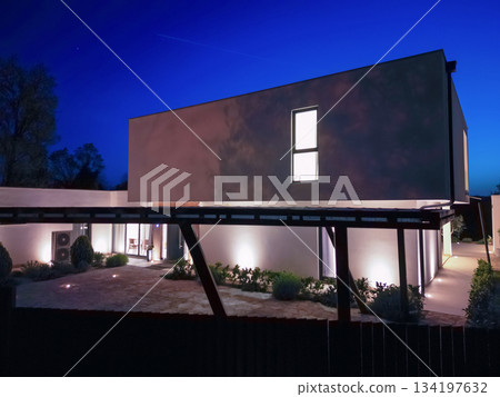 Modern luxury villa illuminated at night with pool, terraces, and contemporary architecture. Warm lighting and elegant outdoor living create a stylish and sophisticated atmosphere 134197632