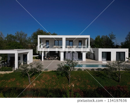 Modern luxury villa with pool, terraces, and clean minimalist architecture captured by drone. Bright sunny day, surrounding greenery, and contemporary outdoor living areas Modern luxury villa with pool, terraces, and clean minimalist architecture captured by drone. Bright sunny day, surrounding greenery, and contemporary outdoor living areas 134197636