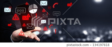 Mobile security threat, warning sign on a smartphone held in a hand against a blurred cityscape background. Showing the risk of data breach or malware infection. Concept of Information Overload 134197818