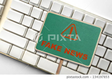 Fake news warning sign with a triangle and exclamation point, symbolizing the spread of misinformation and the importance of verifying online information. Concept of Hoax news 134197853