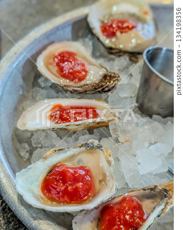 Closeup of fresh oysters on ice with lemon wedges Closeup of fresh oysters on ice with lemon wedges 134198356