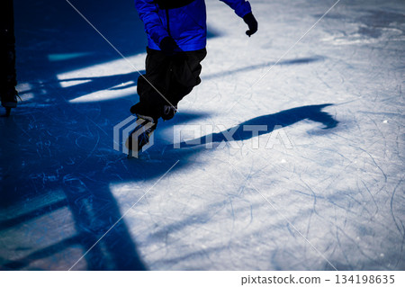 孩子在冰上奔跑,他的影子清晰可見。 孩子在冰上奔跑,他的影子清晰可見。 134198635