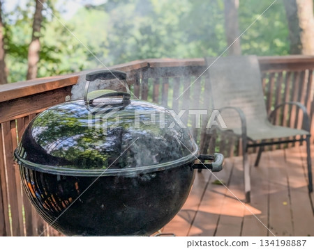Summer picnic with small charcoal grill and steaks on deck Summer picnic with small charcoal grill and steaks on deck 134198887
