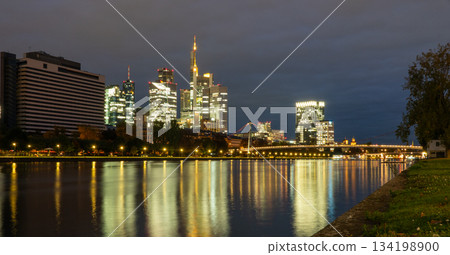 Frankfurt skyline in the evening. Sunset at blue hour with illuminated skyscrapers from the financial and business district Frankfurt skyline in the evening. Sunset at blue hour with illuminated skyscrapers from the financial and business district 134198900