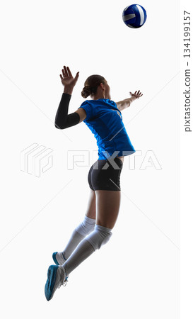 High-jumping teenage volleyball player reaching upward for powerful serve. High-jumping teenage volleyball player reaching upward for powerful serve. 134199157