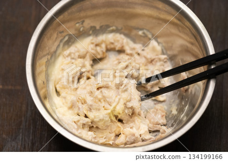 Mixing boiled white fish with mayonnaise in a bowl Mixing boiled white fish with mayonnaise in a bowl 134199166
