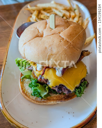 Beef hamburger. Sandwich with beef burger, tomatoes, cheese, pickled cucumber and red onions 134199284
