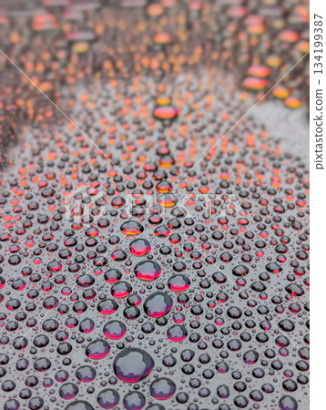 Close up view of water drops on redish surface as background Close up view of water drops on redish surface as background 134199387