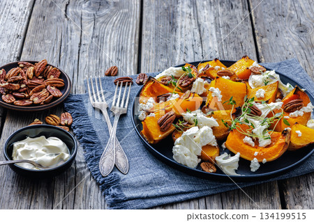 baked butternut squash with cheese, thyme, pecan 134199515