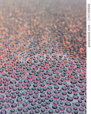 Close up view of water drops on redish surface as background 134199898