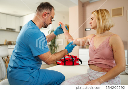 Doctor examining female patient with rash at home Doctor examining female patient with rash at home 134200292