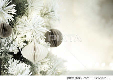 Flocked christmas tree with elegant paper ornaments. Color of 2026 year dancer in the white cloud Flocked christmas tree with elegant paper ornaments. Color of 2026 year dancer in the white cloud 134200399