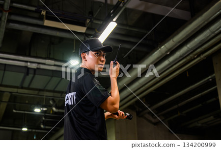 Security guard holding a walkie-talkie 134200999