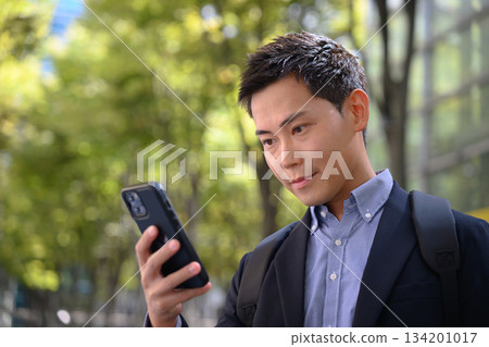 Office worker operating a smartphone Office worker operating a smartphone 134201017