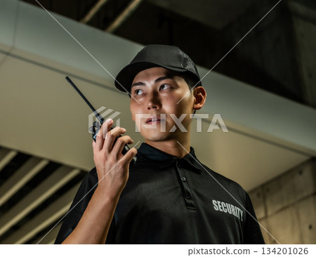 Security guard holding a walkie-talkie 134201026