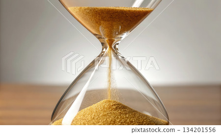 Hourglass filled with golden sand flowing upward, symbolizing Hourglass filled with golden sand flowing upward, symbolizing 134201556