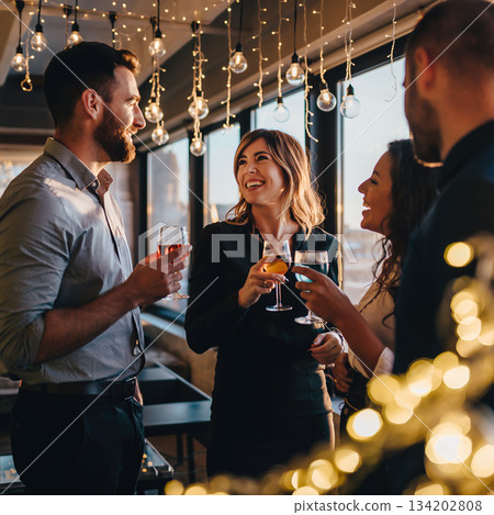 Friends enjoy drinks and conversation at a stylish gathering in a city setting during the evening hours 134202808