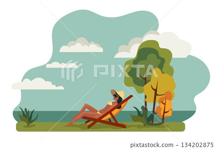 A person sits on a lounge chair by the shore, looking out at the ocean. There are trees around and clouds in the sky. It is a summer day and a vacation vibe is present A person sits on a lounge chair by the shore, looking out at the ocean. There are trees around and clouds in the sky. It is a summer day and a vacation vibe is present 134202875