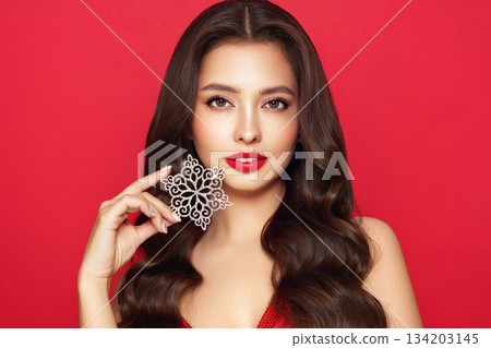 Beautiful young woman with glowing snowflake 134203145