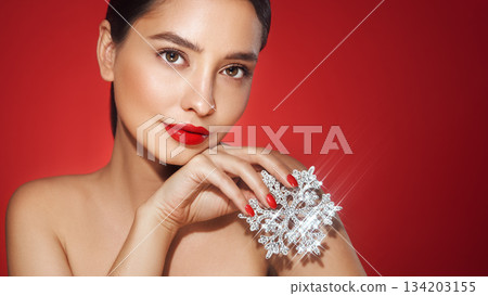 Beautiful young woman with glowing snowflake 134203155