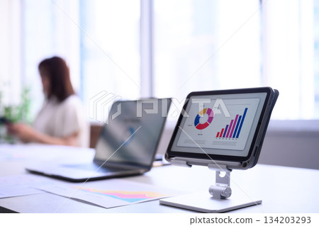 Japanese female business person analyzing business performance data on a tablet 134203293