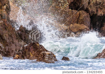 海浪拍打礁岩激起的雪白浪花 134203493
