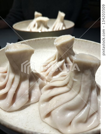 Georgian khinkali dumplings on round plates. Vertical food photo Georgian khinkali dumplings on round plates. Vertical food photo 134203509