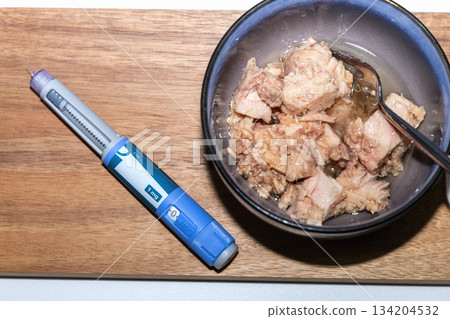 Diet concept with tuna cans and Ozempic pen Diet concept with tuna cans and Ozempic pen 134204532
