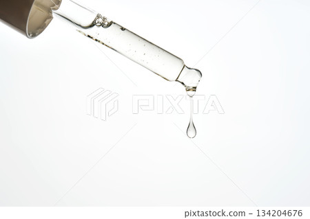 Cosmetic pipette dispensing a liquid serum drop Cosmetic pipette dispensing a liquid serum drop 134204676