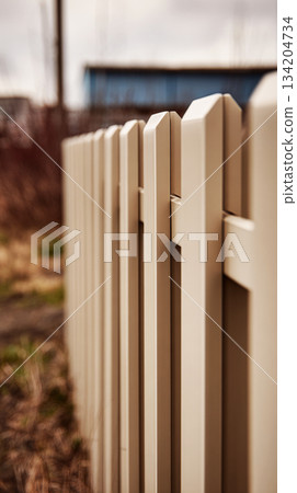 Close-up of modular fence panels in a sand color, highlighting geometric patterns and panel joints. This design creates a modern and stylish outdoor boundary Close-up of modular fence panels in a sand color, highlighting geometric patterns and panel joints. This design creates a modern and stylish outdoor boundary 134204734