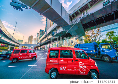 Tokyo cityscape in Japan. The hustle and bustle of December... Postal delivery vehicles pass one after another in the Shiodome business district. Dentsu headquarters is in the far right. Tokyo cityscape in Japan. The hustle and bustle of December... Postal delivery vehicles pass one after another in the Shiodome business district. Dentsu headquarters is in the far right. 134204833
