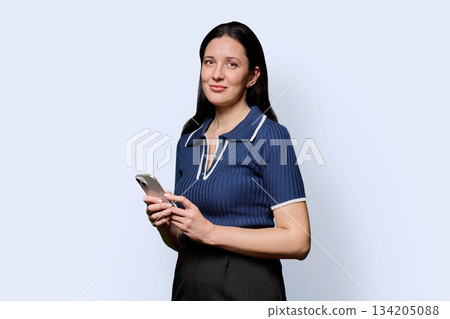 Portrait of successful middle-aged woman with smartphone on white background 134205088