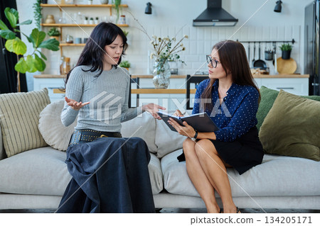 Female social worker working at home with young woman 134205171