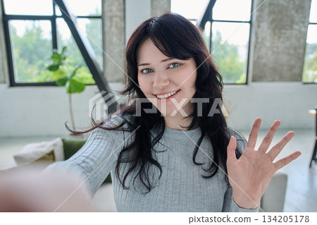 Selfie portrait happy beautiful young woman in home interior 134205178