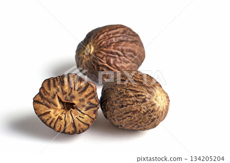 three dried aromatic nutmegs isolated on white background. 134205204