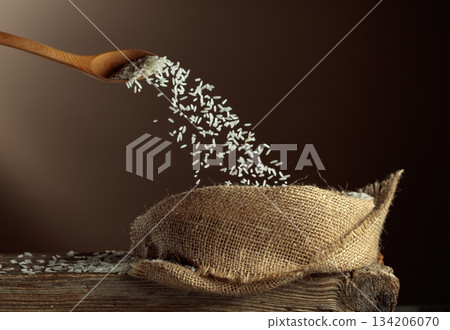 Rice is poured into a burlap bag. Rice is poured into a burlap bag. 134206070