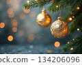 Christmas tree branch decorated with golden baubles and lights 134206096