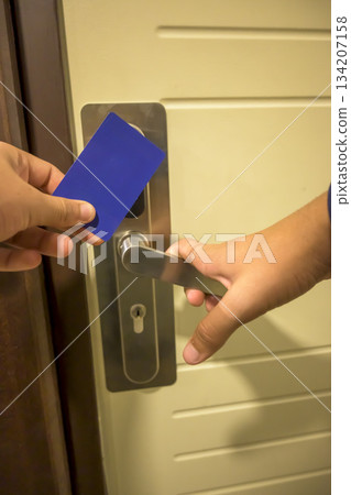 A hand inserting a blue card key into a modern hotel door lock, key electronic lock, hotel room, holidays in mallorca, spain A hand inserting a blue card key into a modern hotel door lock, key electronic lock, hotel room, holidays in mallorca, spain 134207158