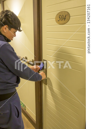 Latin young men opens a door with a keycard in a hallway, key electronic lock, hotel room, holidays in mallorca, spain Latin young men opens a door with a keycard in a hallway, key electronic lock, hotel room, holidays in mallorca, spain 134207161