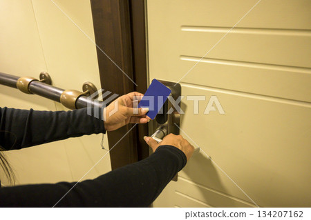 Latin Woman opens a door with a keycard in a hallway, key electronic lock, hotel room, holidays in mallorca, spain Latin Woman opens a door with a keycard in a hallway, key electronic lock, hotel room, holidays in mallorca, spain 134207162