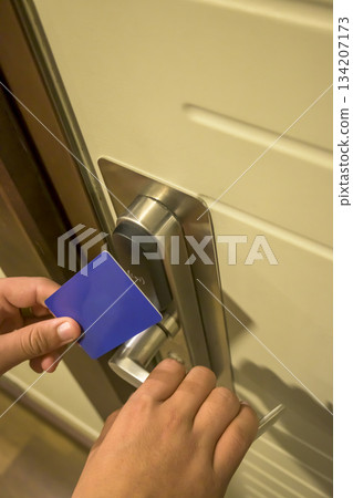 Close-up of a hand using a blue card key on a hotel door lock, key electronic lock, hotel room, holidays in mallorca, spain Close-up of a hand using a blue card key on a hotel door lock, key electronic lock, hotel room, holidays in mallorca, spain 134207173