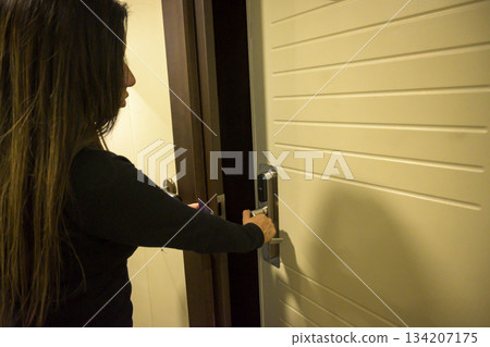 Latin Woman opens a door with a keycard in a hallway, key electronic lock, hotel room, holidays in mallorca, spain Latin Woman opens a door with a keycard in a hallway, key electronic lock, hotel room, holidays in mallorca, spain 134207175