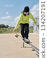 young, teenager, with a skateboard, jumping, on a track, skateboarding, wearing headphones 134207191