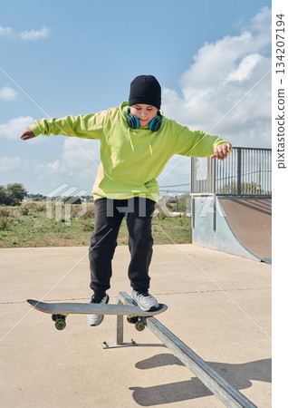 young, teenager, with skateboard, jumping, on the track, with headphones, 134207194