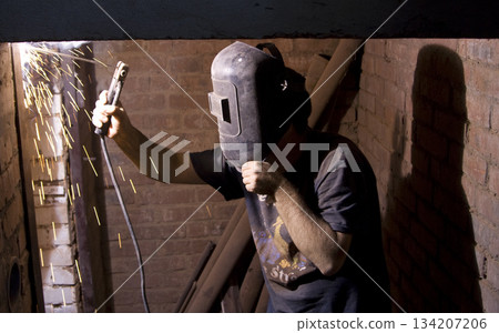 Welder with protective gloves and helmet welding steel Welder with protective gloves and helmet welding steel 134207206