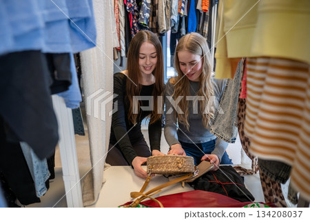 Women choosing clothes together in secondhand store Women choosing clothes together in secondhand store 134208037