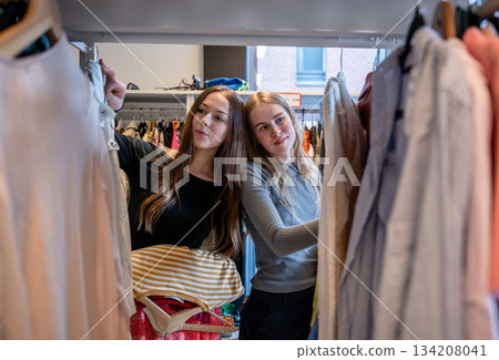 Women choosing clothes together in secondhand store 134208041