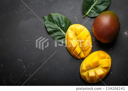 Ripe tropical sliced whole mangoes leaves dark background healthy exotic fruit copy space Ripe tropical sliced whole mangoes leaves dark background healthy exotic fruit copy space 134208141