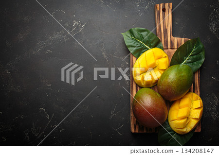 Fresh mango exotic fruit sliced whole cutting board dark background preparing copy space 134208147